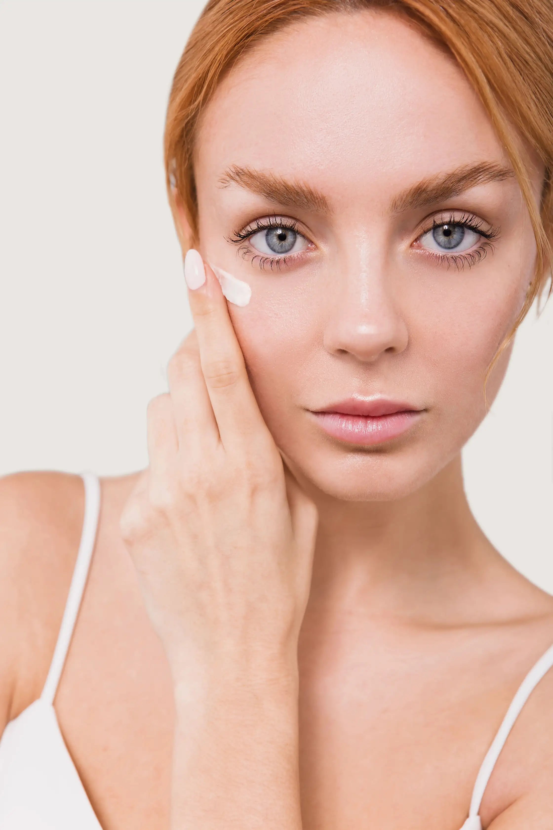 Modelo con crema de contorno de ojos de día The Looking Good Eye Treatment sobre el rostro