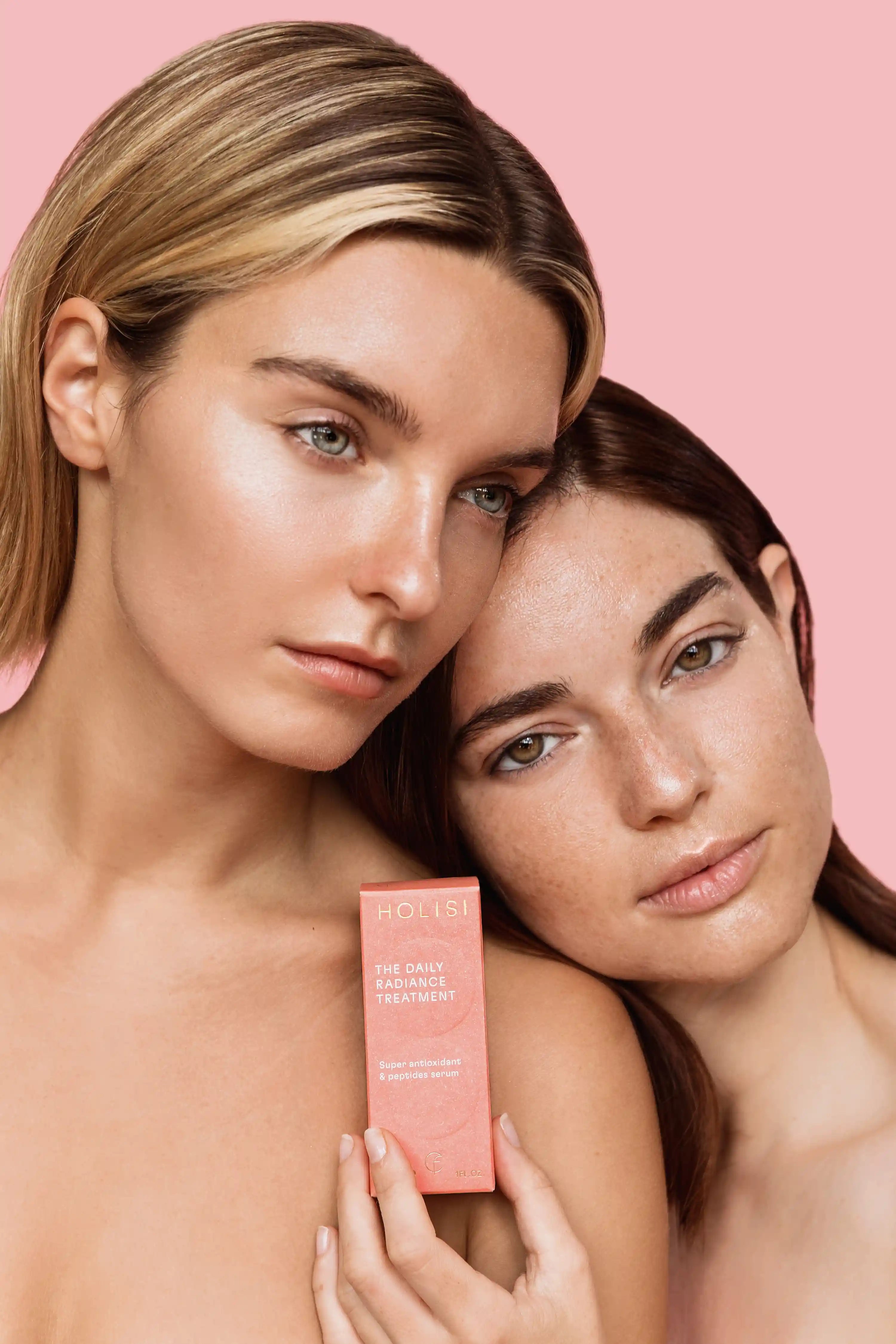 Chicas sosteniendo el packaging del sérum con vitamina C The Daily Radiance Treatment.