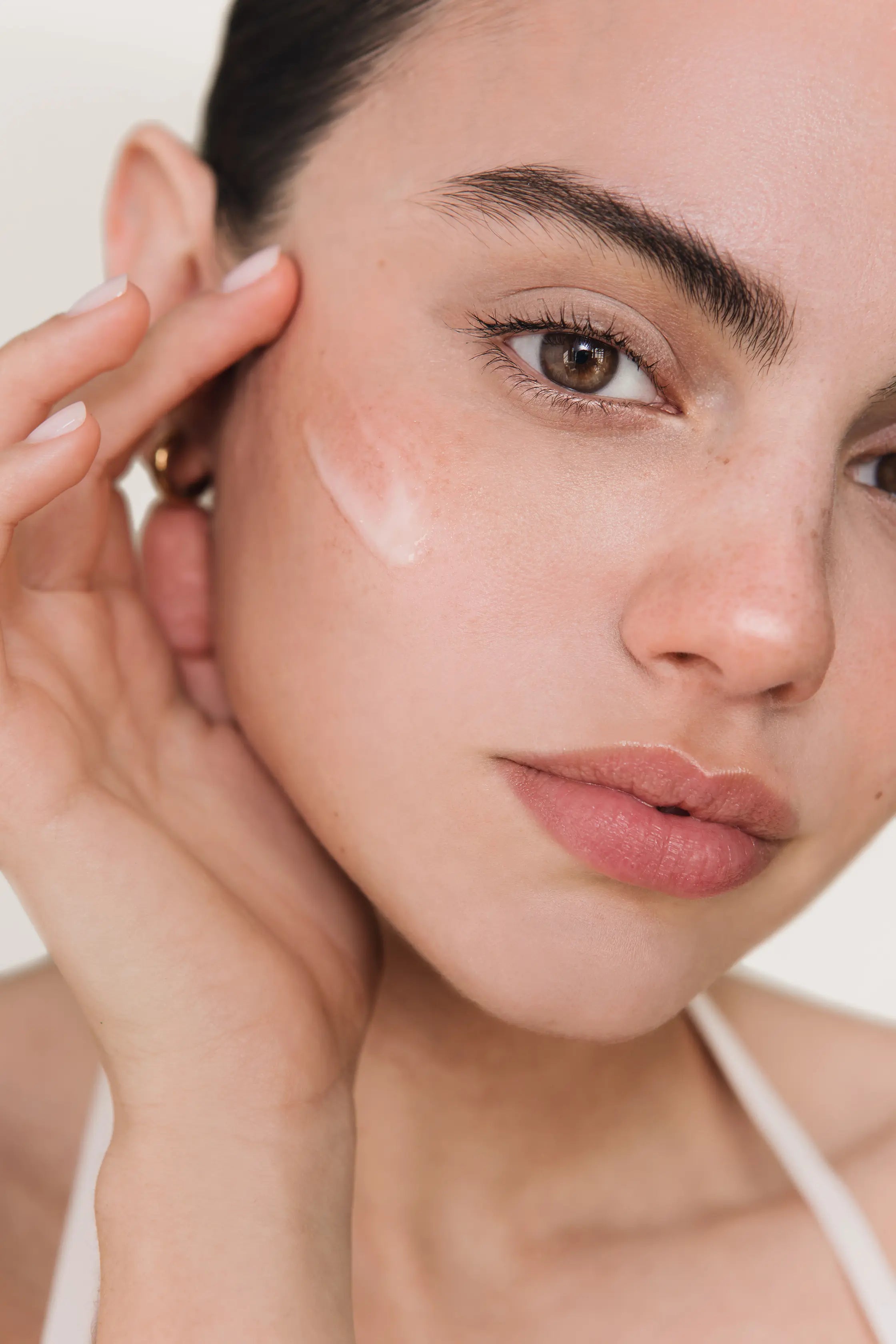 Modelo aplicando la esencia The Reset Milk Therapy sobre la cara