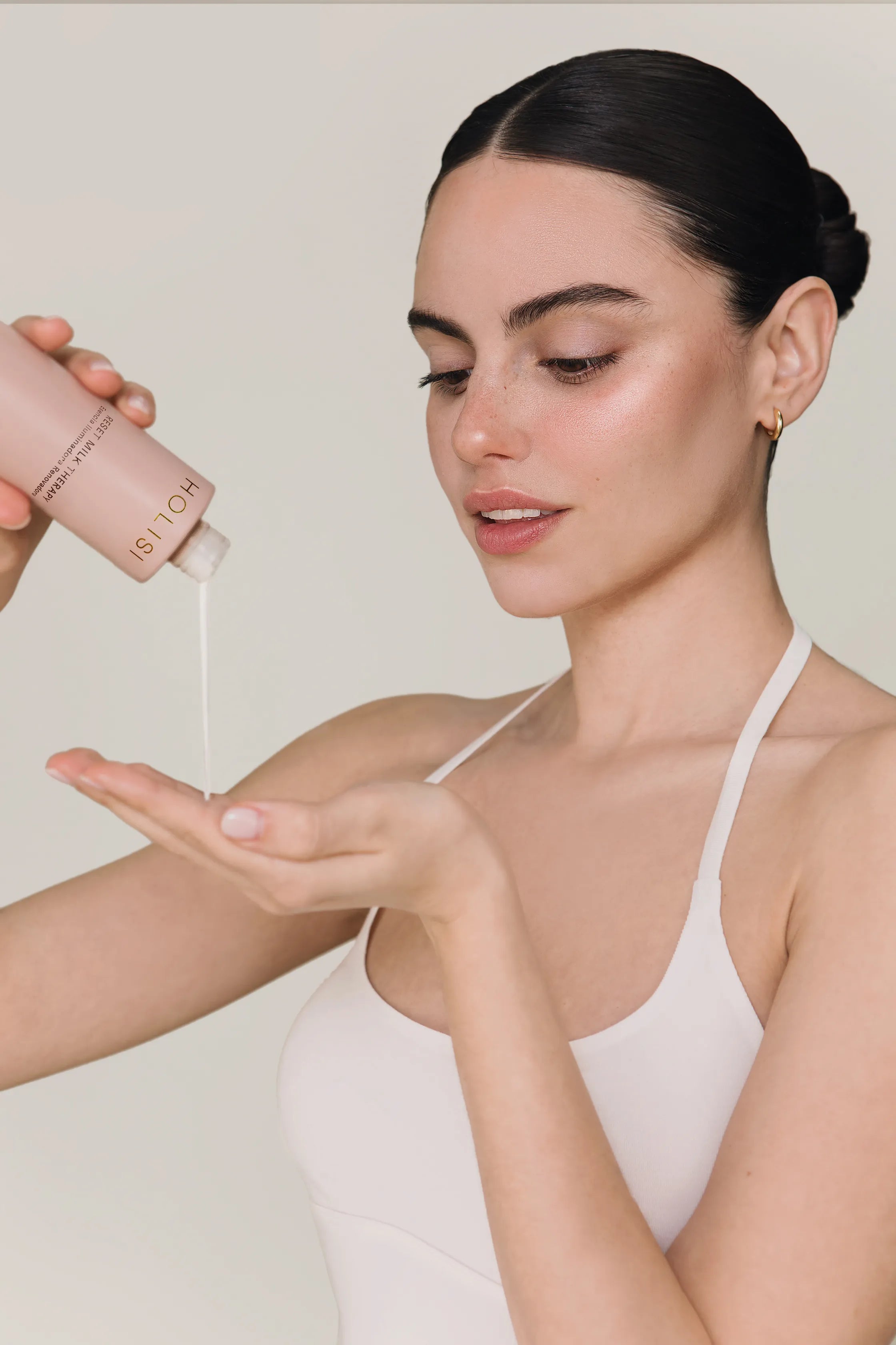 Modelo echando la esencia The Reset Milk sobre la mano