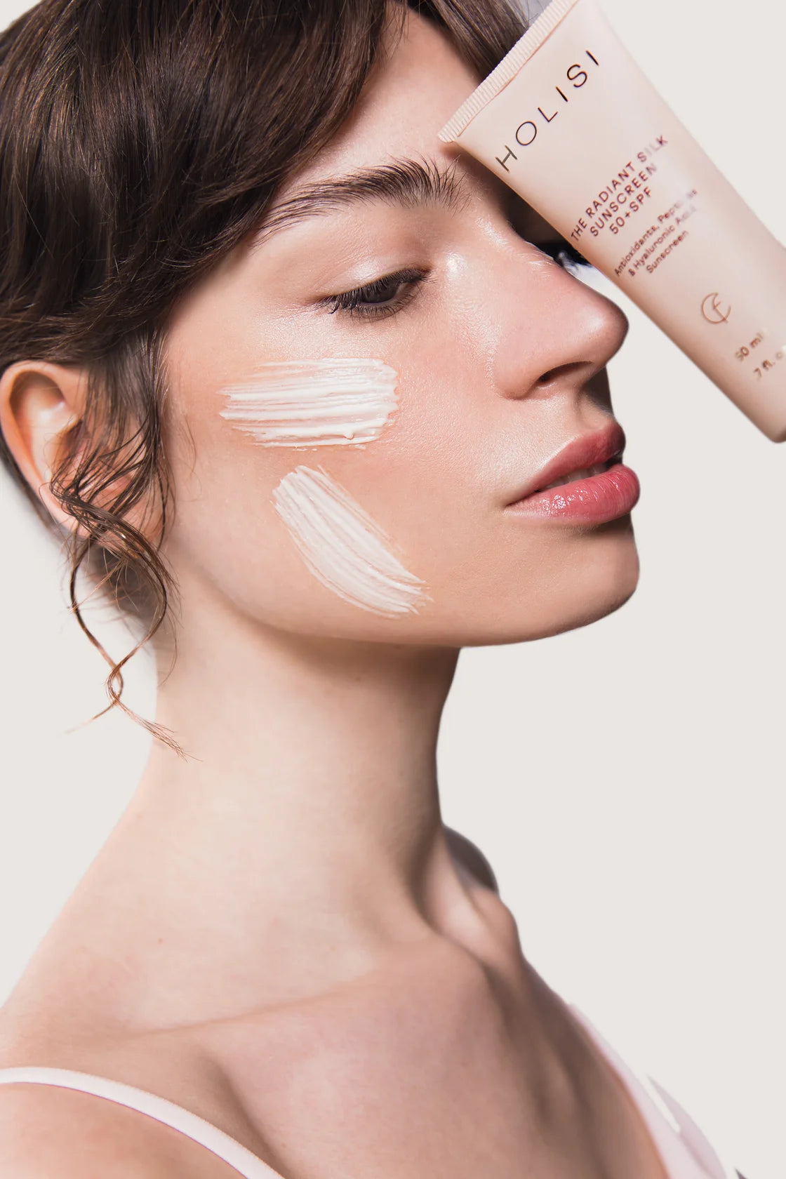 Modelo con protector solar The Radiant Silk Sunscreen 50+ SPF sobre el rostro