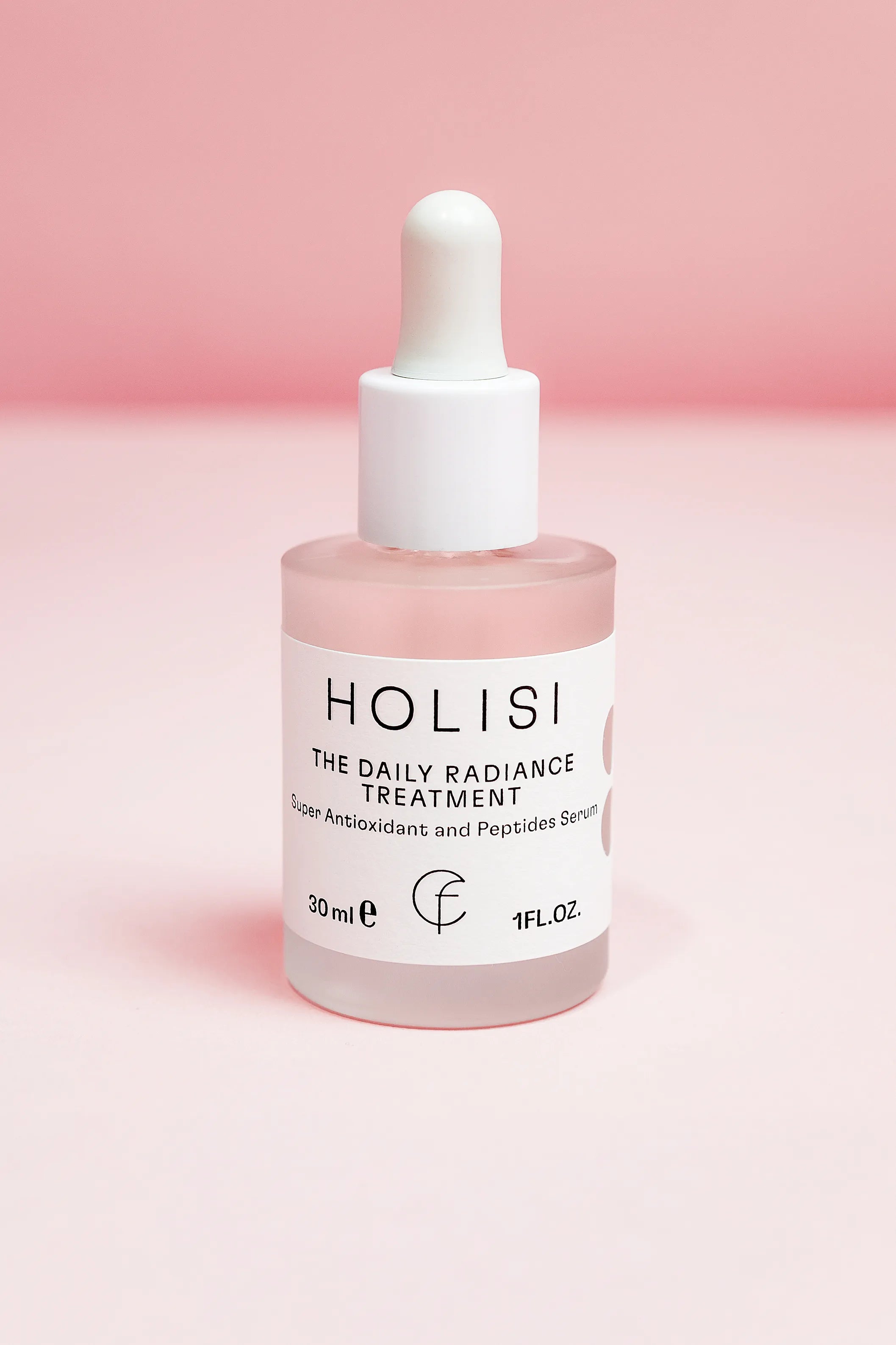Imagen del frasco de The Daily Radiance Treatment sobre un fondo rosado.