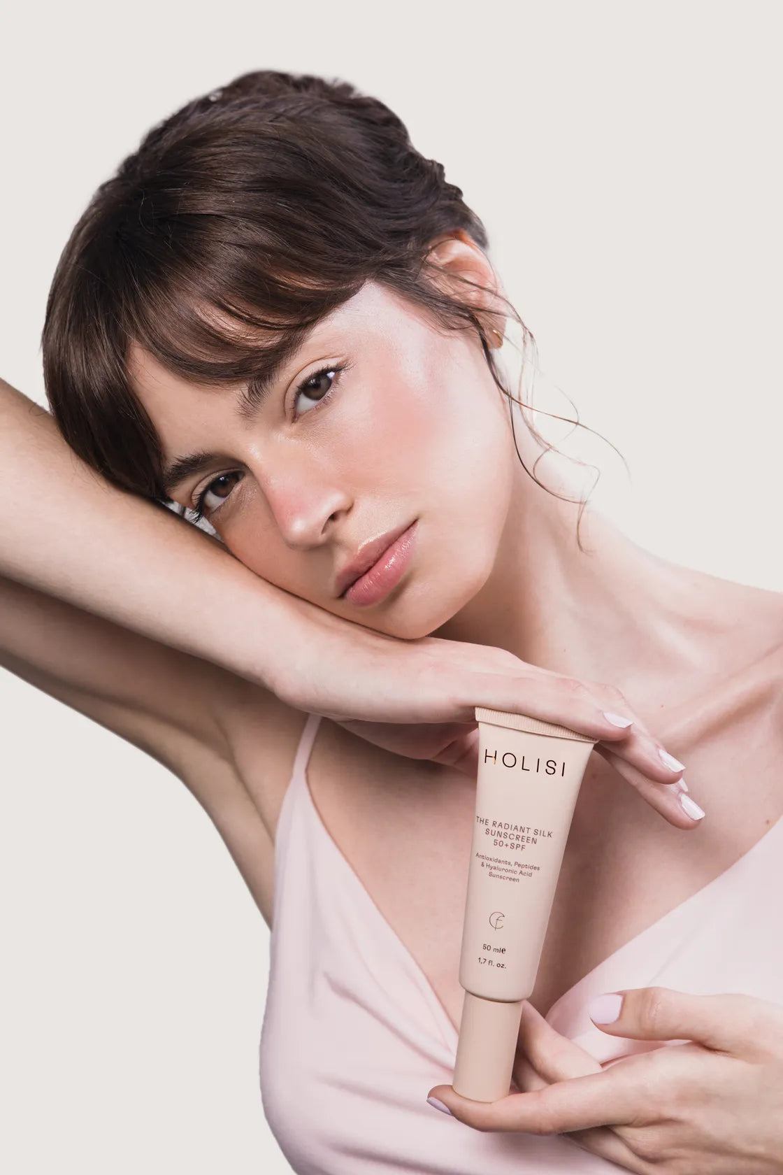 Mujer posando con la crema solar de Holisi