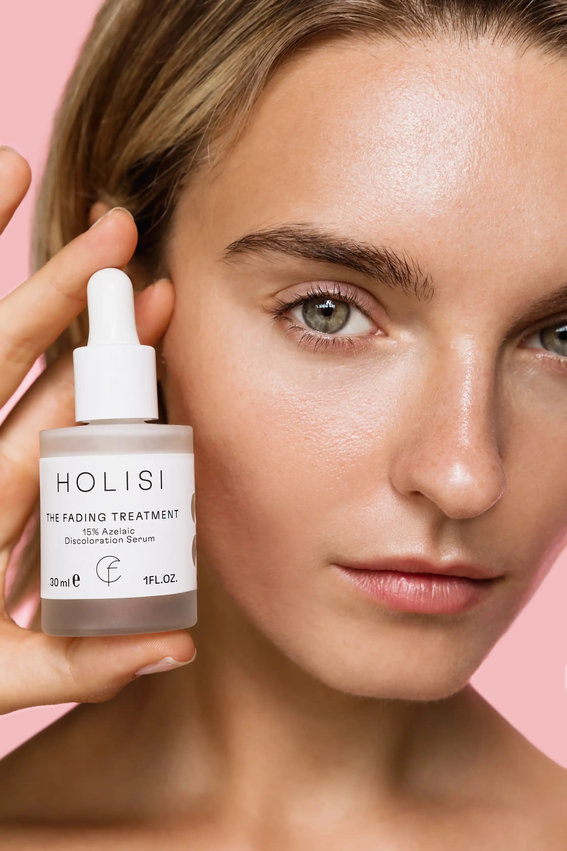 Frasco del serum despigmentante The Fading Treatment de Holisi sobre la mano de modelo