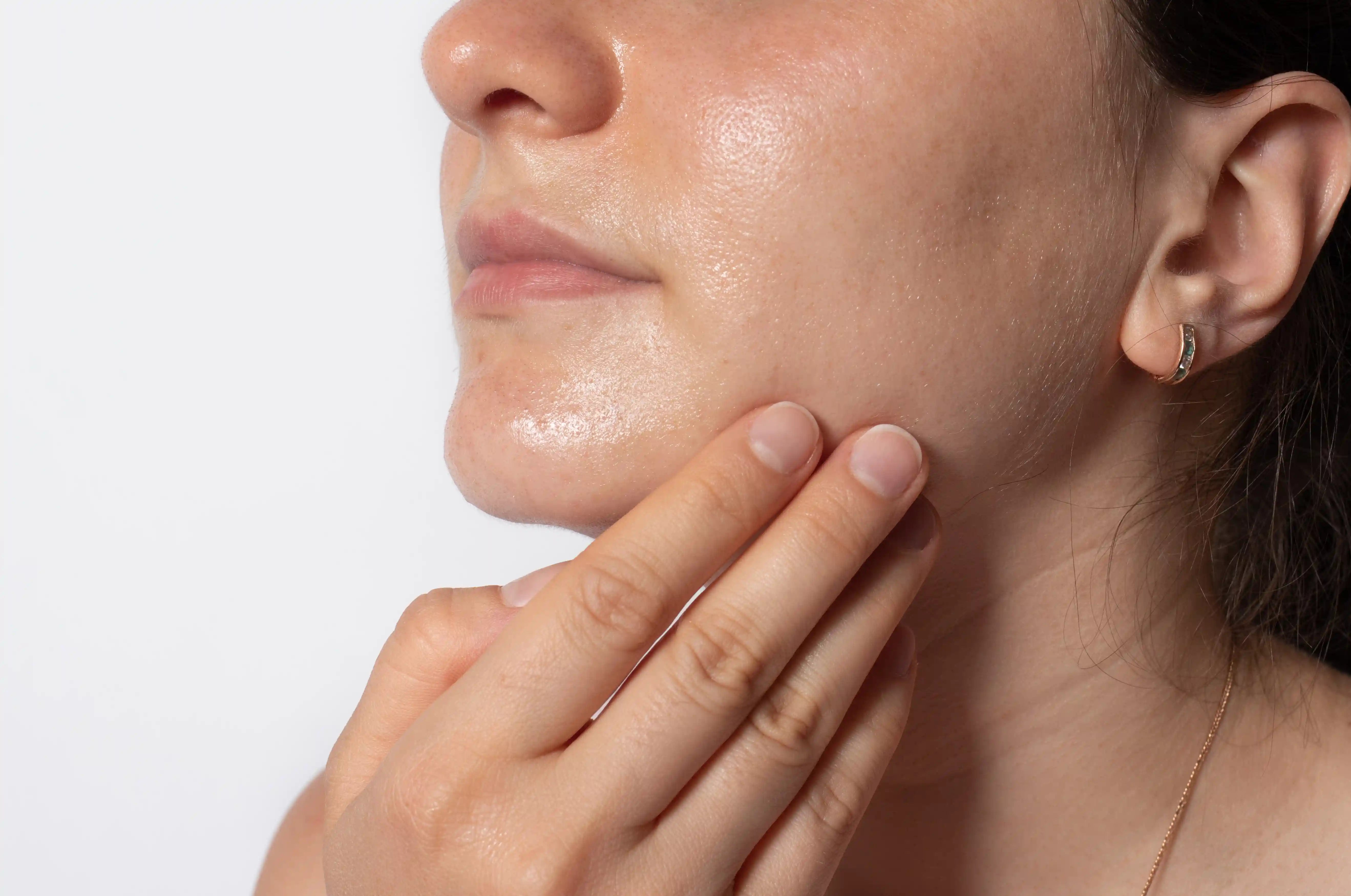 Mujer de perfil aplicando el tratamiento de Holisi para lograr luminosidad en su piel apagada